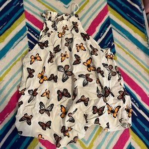 A butterfly tank top the colors are white, orange and black